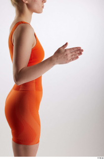 Unaisa  1 arm dressed flexing orange sports bra side…